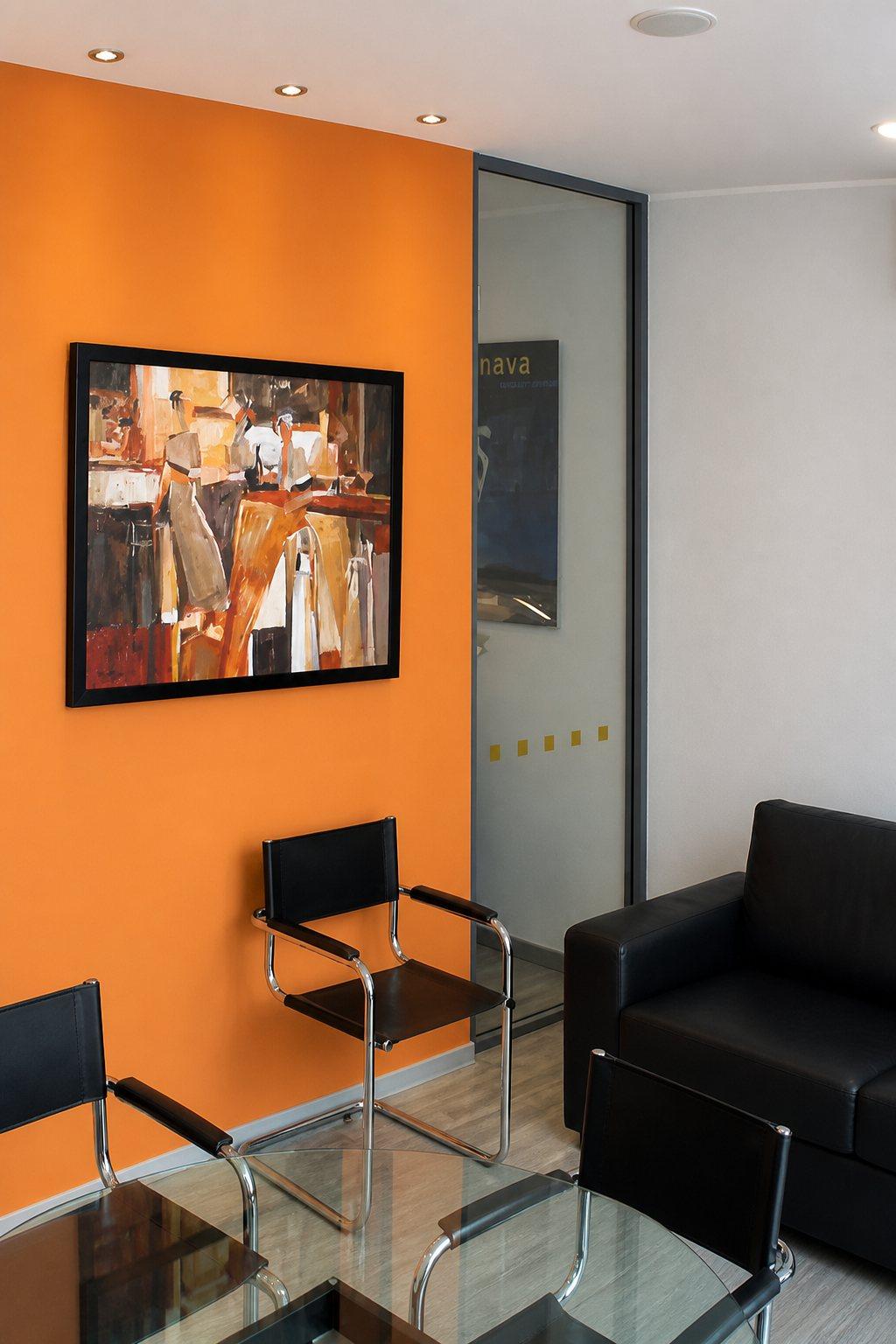 Sala d’attesa con parete arancione e dipinto astratto